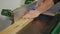 Carpenter hands using wood planer machine to plane wood in a carpentry workshop