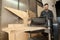 Carpenter joiner working on stationary power planer with wooden