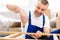 Carpenter Making Wooden Shelf Using Screwdriver, Wearing Blue Coverall Indoor