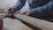 A carpenter measures a wooden board with a square at an angle and marks the dimensions with a pencil. 4k. 4k video. Slow motion.