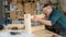 Carpenter measures wooden planks in the workshop.