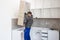 The carpenter places the newly assembled kitchen shelves in the intended place