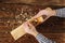 Carpenter planes a workpiece on a workbench. carpenter`s hands. old wooden plane