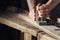 Carpenter planing a plank of wood with a hand plane