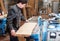 Carpenter plans a board in a carpentry workshop on a large stationary machine