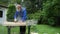 Carpenter polishing a wooden board with an electric sander in garden yard
