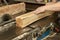 a carpenter processes wood on a machine