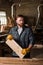 carpenter in protective gloves working with wooden plank