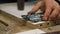 Carpenter\'s hand is preparation for fastening a metal part to a piece of furniture. Slow motion. Selective focus