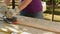 Carpenter sanding wood planks with sand machine