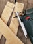 A carpenter saws plywood with a jigsaw