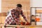 Carpenter shaping wooden bar with hand plane at table