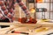 Carpenter shaping wooden bar with plane at table in workshop, closeup