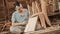 Carpenter sitting on the floor holding a carpenter elbow ruler