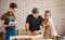 Carpenter with students in woodworking workshop