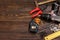 Carpenter tools on a wooden table. A screwdriver, hummer, drive screws, measuring tape and dowels on a wooden tray. Drills, wire