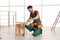 Carpenter in uniform making furniture. Professional construction tools