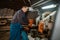 Carpenter in uniform near woodworking machine