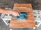 The carpenter use electric sander polish wood board