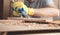 Carpenter using chisel into wooden plank