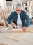 Carpenter Using Electric Sander At Table