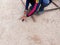 The carpenter is using the hammer to pull the nails out of the wood on the sandy background.