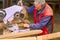 Carpenter is using hand held circular saw to cut boards, making clean precise cut