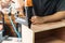 Carpenter using nail gun or brad nailer tool on wood box in a workshop ,furniture restoration woodworking concept. selective focus