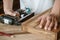 carpenter using nail gun or brad nailer tool on wood box in a workshop ,furniture restoration woodworking concept. selective focus