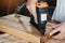 carpenter using nail gun or brad nailer tool on wood box in a workshop ,furniture restoration woodworking concept. selective focus