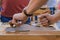 Carpenter using spokeshave or plane to shape wood board - close up side view