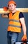 Carpenter, woodworker, labourer, builder on calm face carries wooden beams on shoulder. Man in helmet, hard hat holds