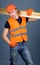 Carpenter, woodworker, labourer, builder on confident face carries wooden beams on shoulder. Man in helmet, hard hat and