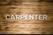 CARPENTER word made of wooden block letters on wooden board.