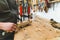 Carpenter during work. Woodworking expert glueing two wood pieces together with bar clamps. Indoor closeup shot.