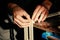 Carpenter at workbench nails down small wooden box.Hands of worker with old axe.Authentic workflow in carpentry workshop