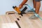 Carpenter worker installing wood parquet board with hammer