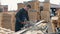 Carpenter worker wearing construction goggles using wood cutting machine. man cuts wooden planks.