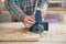 Carpenter Working With Electric Planer On Wood