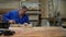 Carpenter working in the Studio, worker planing a tree with a planer