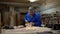 Carpenter working in the Studio, worker planing a tree with a planer