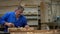 Carpenter working in the Studio, worker planing a tree with a planer