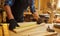 Carpenter working with a wood, marking plank with a pencil and taking measurements to cut a piece of wood to make a piece of