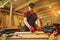 Carpenter working with a wood, marking plank with a pencil and taking measurements to cut a piece of wood to make a piece of