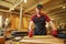 Carpenter working with a wood, marking plank with a pencil and taking measurements to cut a piece of wood to make a piece of