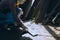 Carpenter is working in a woodworking office.A white male carpenter is selecting the wood material and brushing off the sawdust