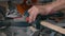 A carpenter works on a circular electric saw. A close-up of the hands of a worker and machine parts. Slow motion footage