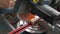 A carpenter works on a circular electric saw. A close-up of the hands of a worker and machine parts. Slow motion footage