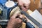 A carpenter works on a lathe on a tree. Hands with a pencil and ruler measure the product