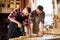 Carpenters with drill drilling board at workshop